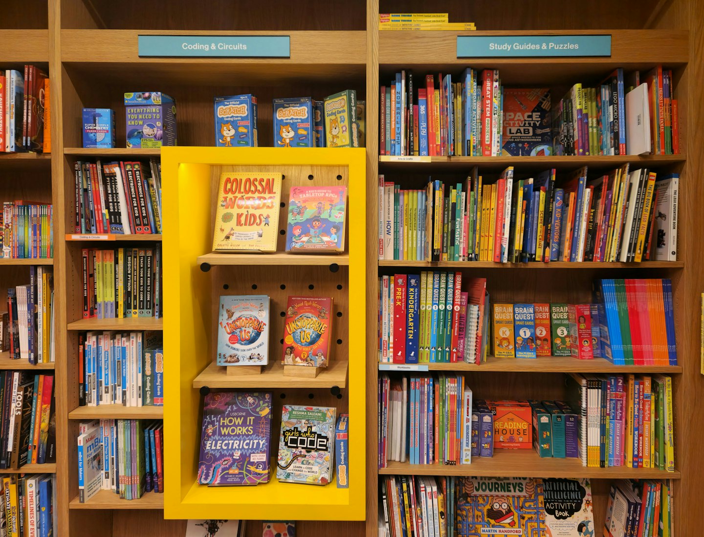 Kinderbücher und Lernspiele in einem Holzregal.