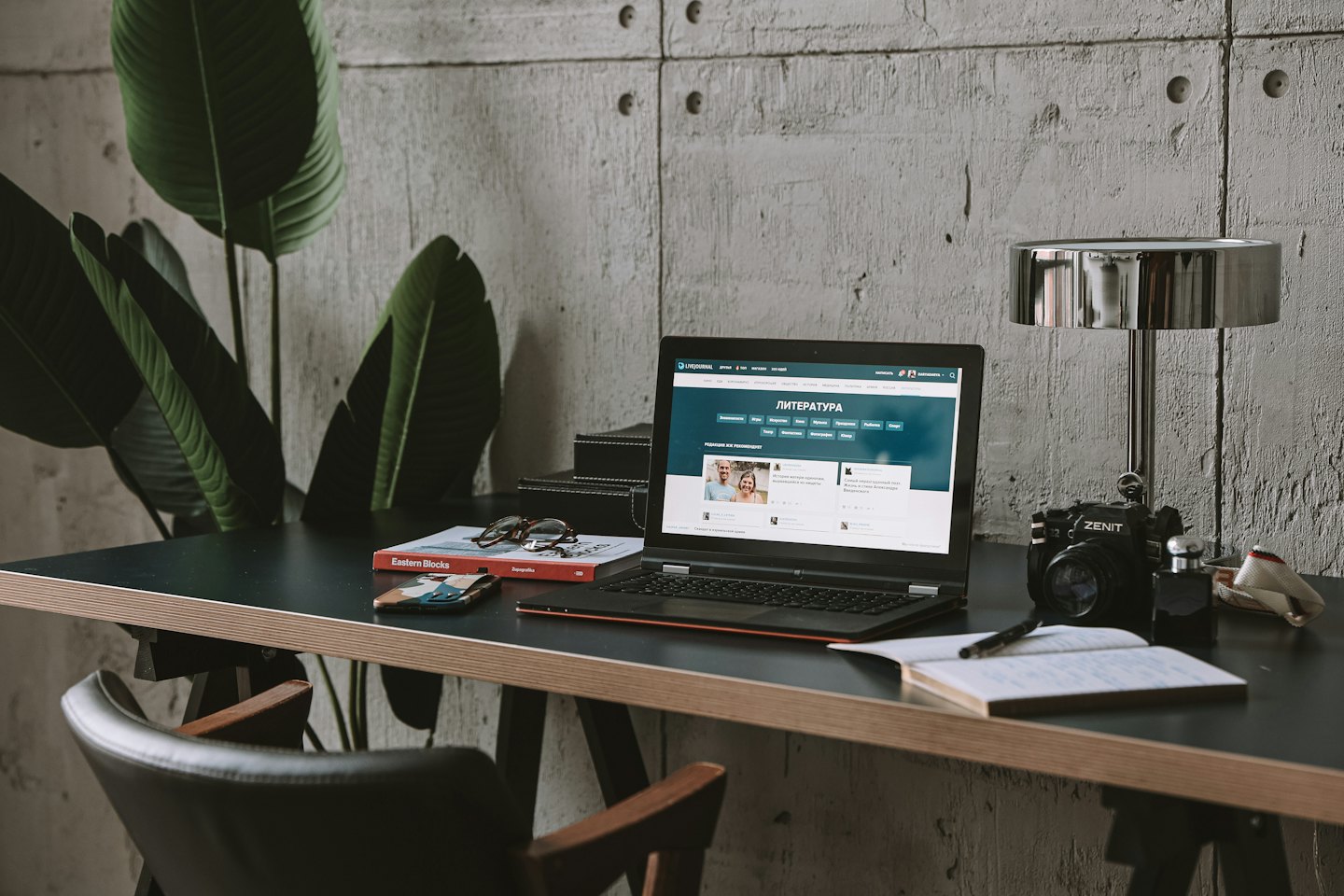 Ein Laptop und Büromaterial liegen auf einem Holztisch.